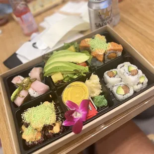 a person holding a tray of sushi