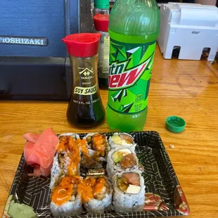 a bottle of mountain dew and a plate of sushi