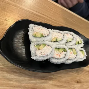 a plate of sushi on a wooden table