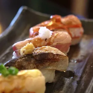 a variety of sushi on a black plate