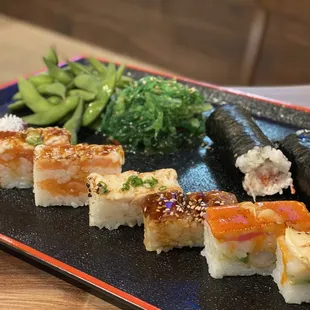 various types of sushi on a black plate