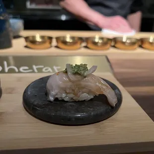 a sushi dish on a black plate