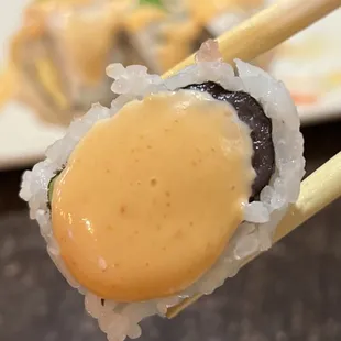 chopsticks holding a piece of sushi