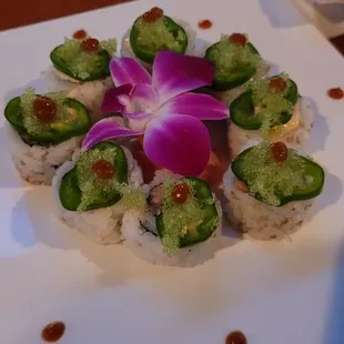 a plate of sushi with a flower on top