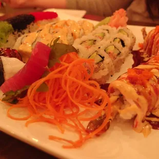 a plate of sushi and vegetables