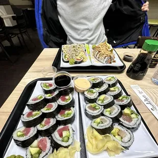 two trays of sushi on a table