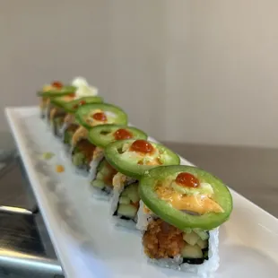 a sushi roll with cucumbers and sauce