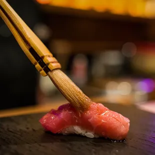 a sushi being served with chopsticks