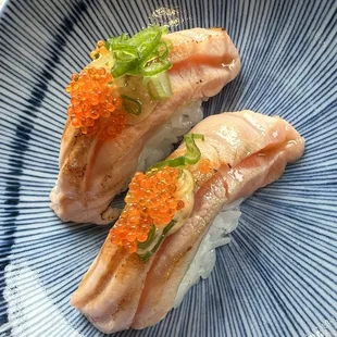 Lightly seared sake toro nigiri topped with tobiko and green onion. It melts in the mouth just like the O-toro.