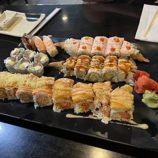 a variety of sushi on a black plate