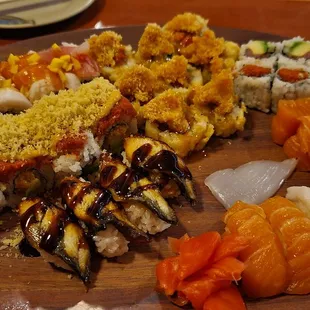 a variety of sushi on a wooden plate
