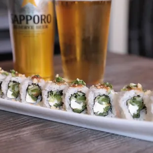 Vegetarian Spicy Sherlock Roll: Cucumber, tempured jalapeno, and cream cheese topped with a miso glaze, macadamia nuts and green onions.