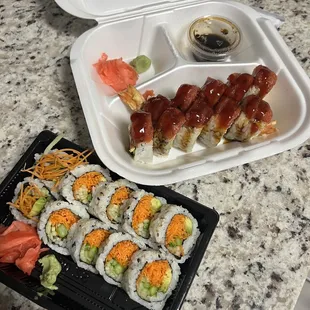 a tray of sushi and a container of sauce