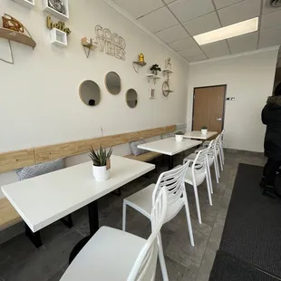 a dining room with white tables and white chairs
