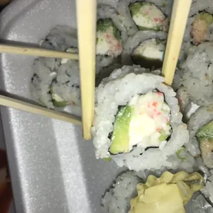 a plate of sushi with chopsticks
