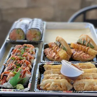 a tray of sushi and rolls