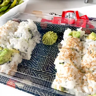 sushi and vegetables in a plastic container