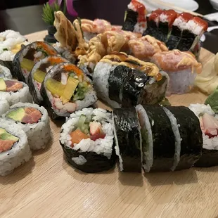 various types of sushi on a wooden plate