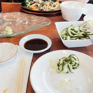 Empty sushi roll platter, cucumber salad with a super sweet / sour vinaigrette, and a ginger side House Salad, bowl of Katsu sauce