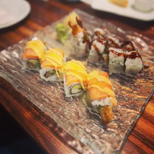 various types of sushi on a glass plate