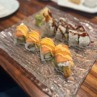 a variety of sushi on a glass plate