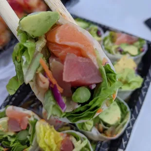 a tray of sushi rolls with chopsticks