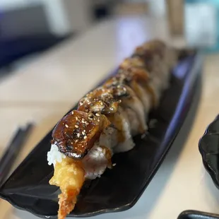 a plate of sushi and chopsticks