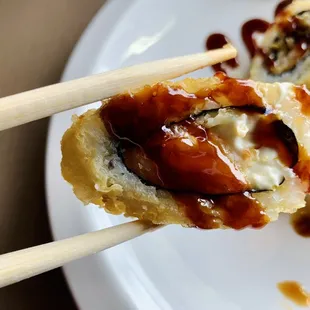 a plate of sushi with chopsticks