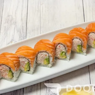 a platter of sushi rolls with sauce and chopsticks