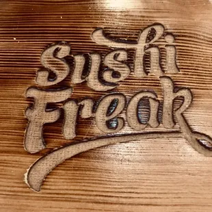 the word sushi freak on a wooden surface
