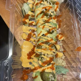 a sushi with avocado and sauce