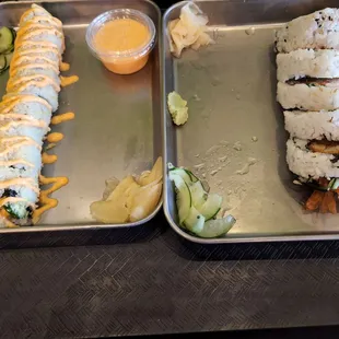 two trays of sushi on a table