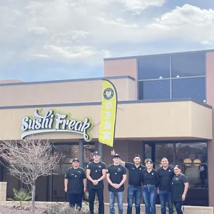 a group of people standing in front of a restaurant