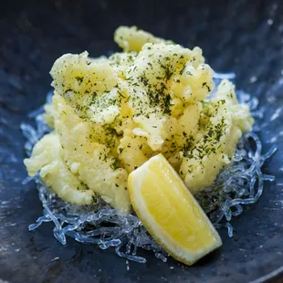 a plate of mashed potatoes with lemon wedges