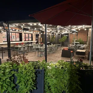 a patio with tables, chairs, and umbrellas