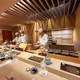 three chefs preparing sushi
