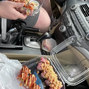 a man holding a tray of sushi