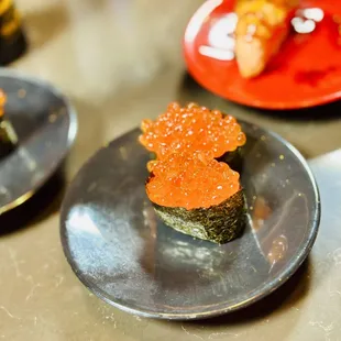 a plate of sushi with red cavia