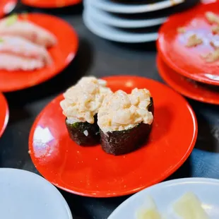 a variety of sushi on red plates