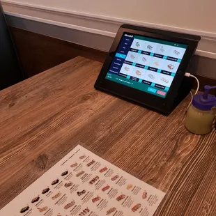 a menu and a tablet on a table