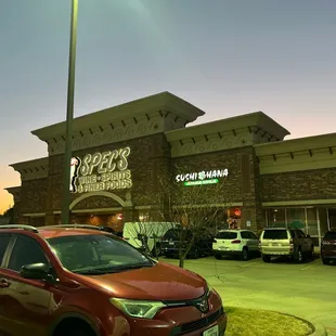 a red toyota rav parked in front of a restaurant