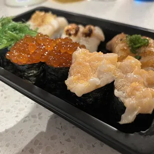 a tray of sushi and cauliflower