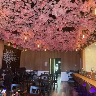 a restaurant with cherry blossoms hanging from the ceiling