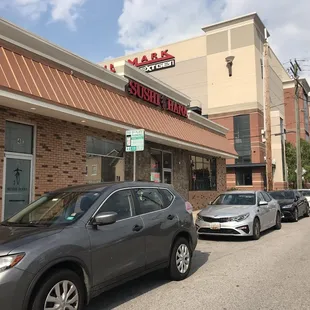 a row of cars parked in front of a restaurant