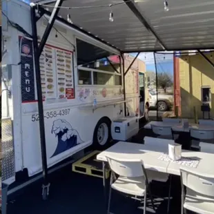 a food truck with tables and chairs