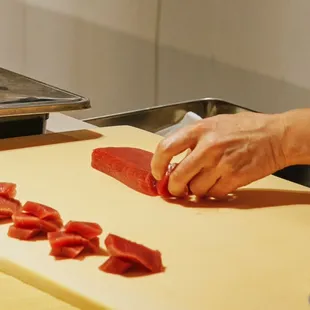 a person chopping meat on a cutting board