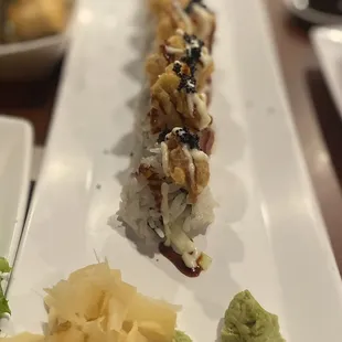 a long roll of sushi on a white plate