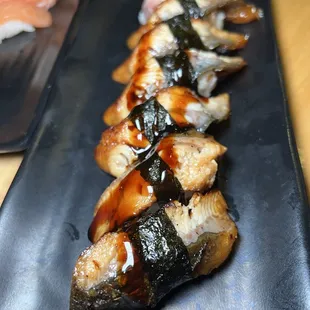 a close up of a sushi on a black plate