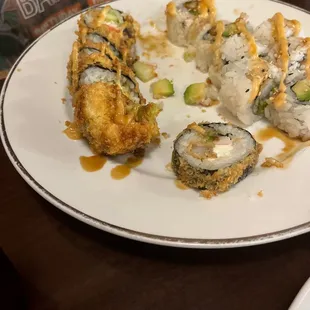 a plate of sushi with sauce on it