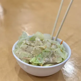 a bowl of food with chopsticks